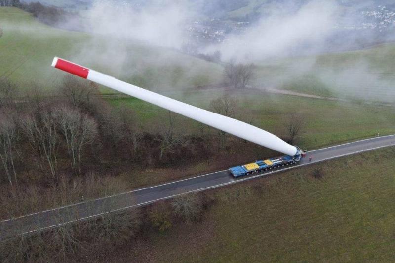 insanely huge windmill propellers are trucked in on a cargo hauler