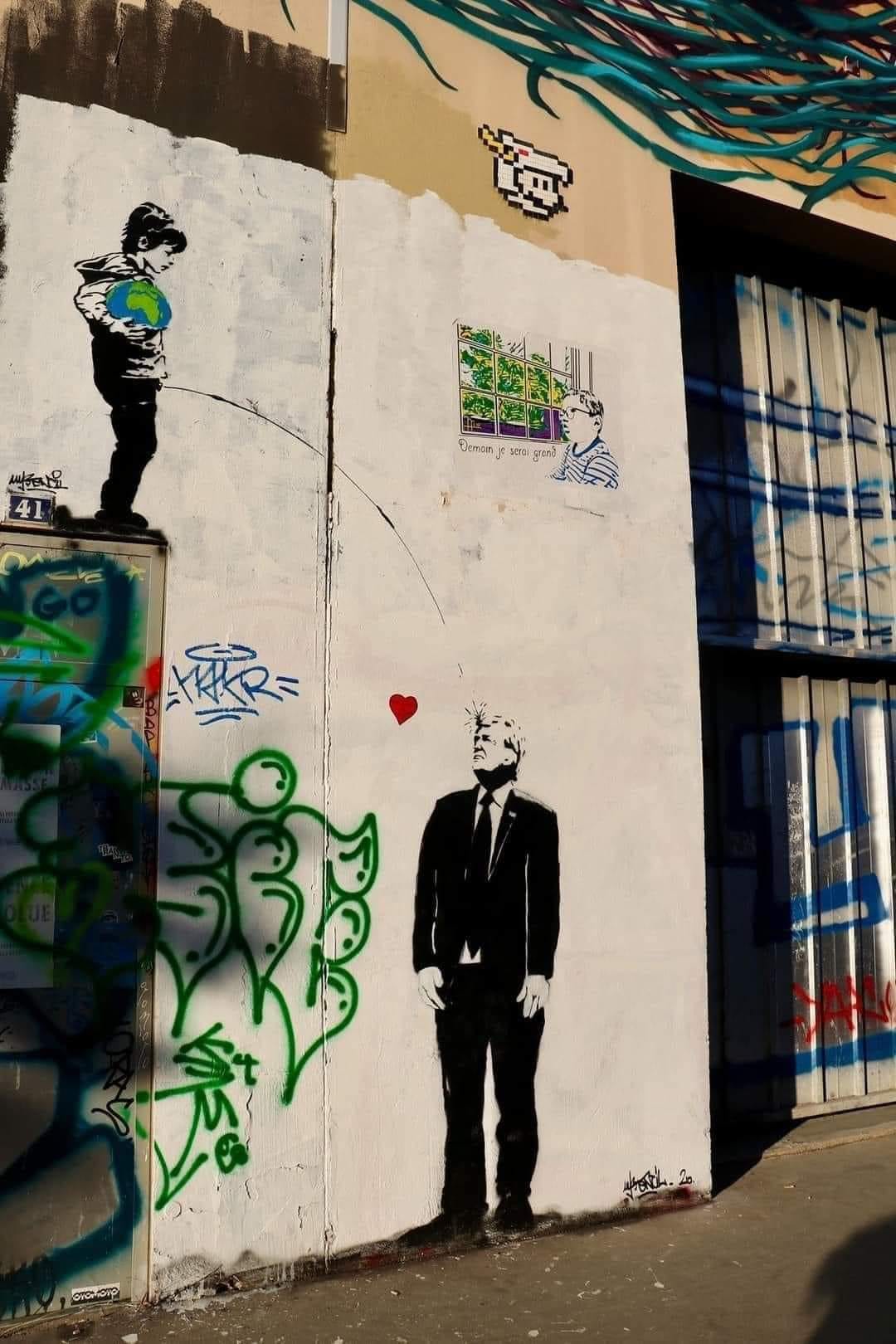 banksy paints a child holding the world peeing on donald trump's face